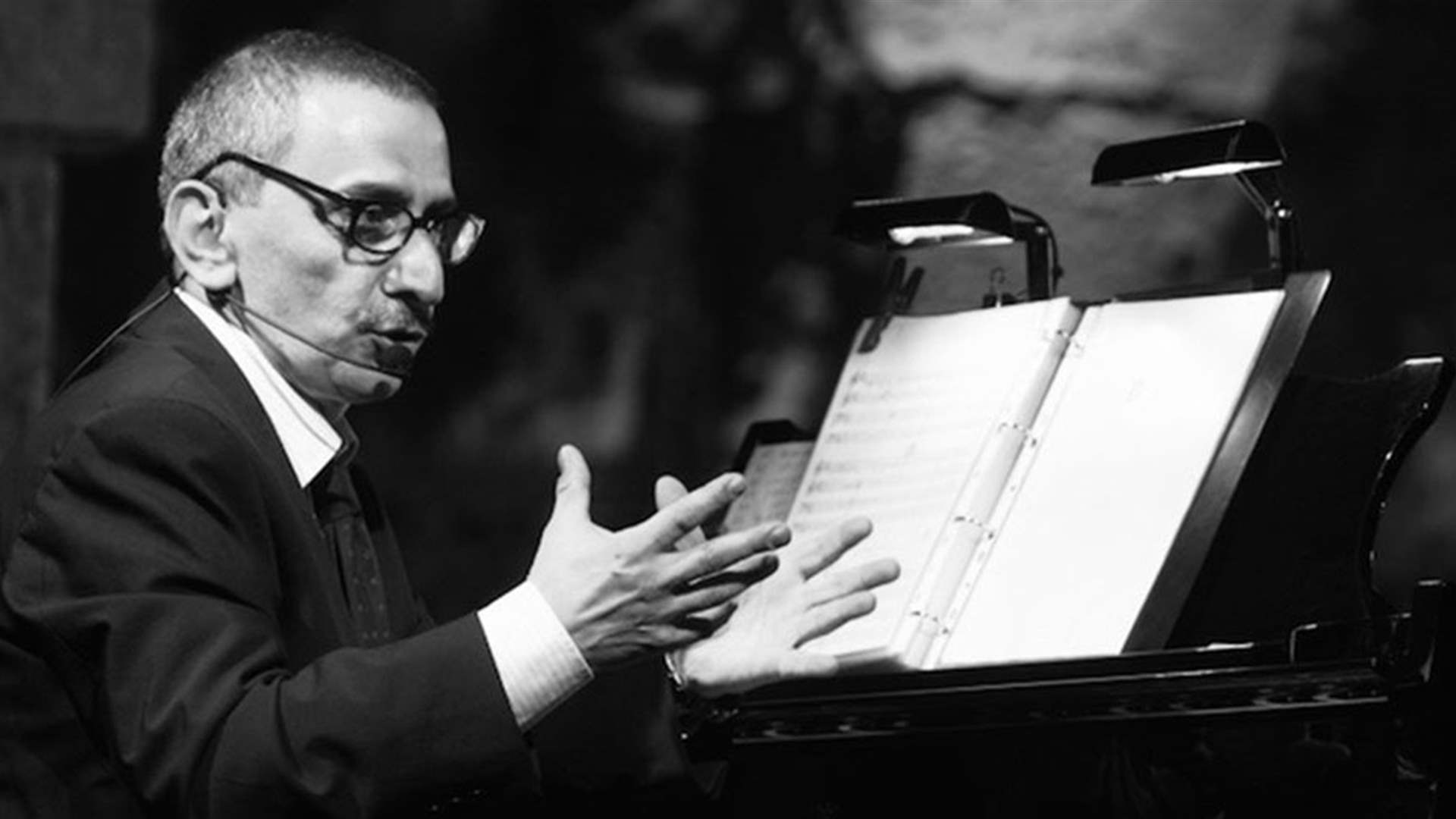 Ziad Rahbani conducting beside a piano